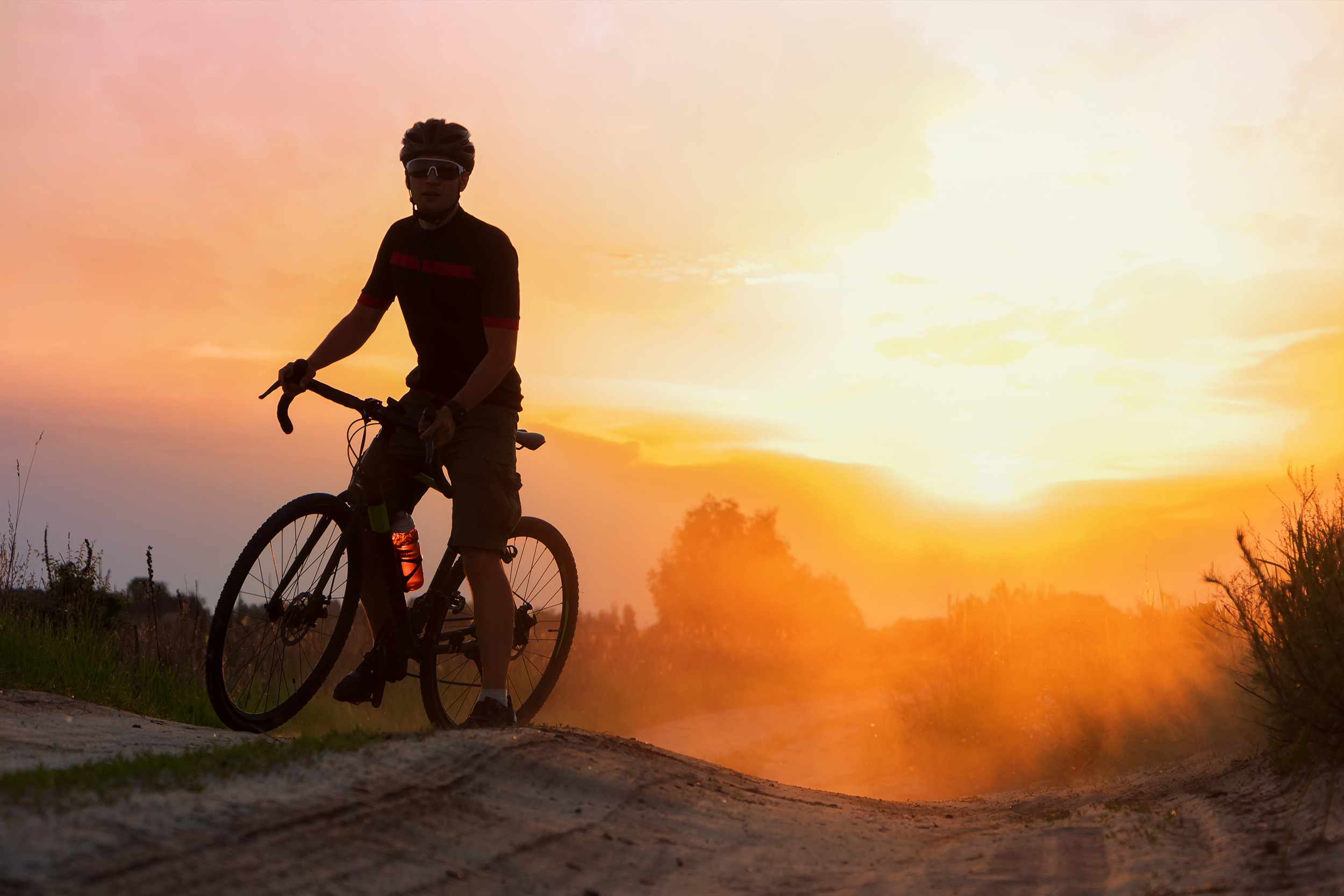 a man on a bike at sunset