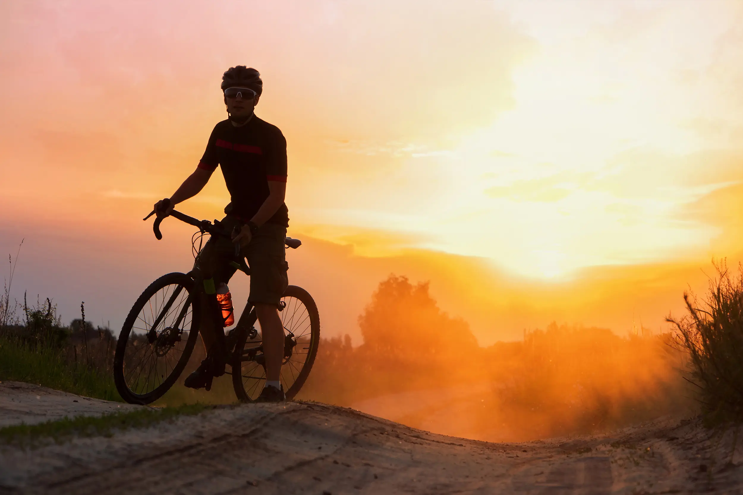 a man on a bike at sunset