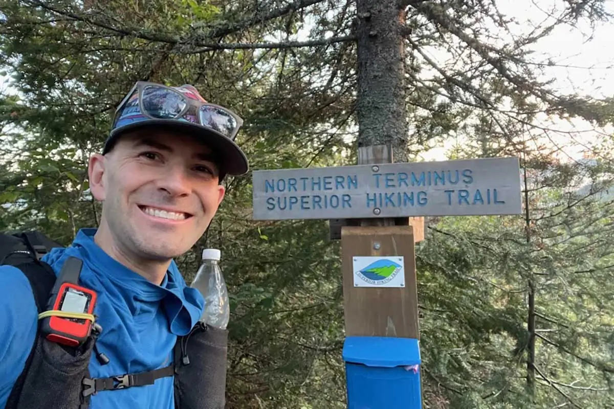 Alan Chapman at the Northern Terminus sign of the Superior Hiking Trail