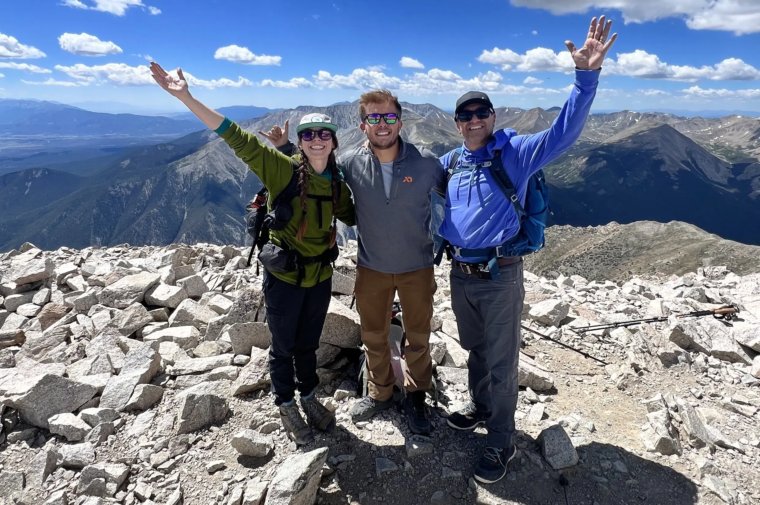 Shelby stands at the summit of a peak in Colorado with clients; (Photo/Sean Krayer)