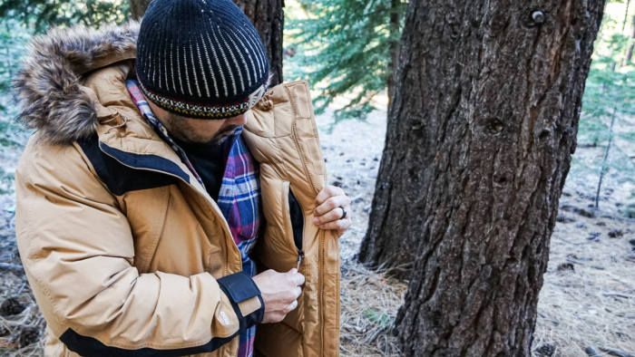 A man demonstrates the inner zippered chest pocket on The North Face McMurdo Down Parka.