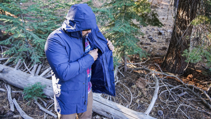 A man demonstrating the inner chest pocket on the Patagonia Tres 3-in-1 Parka.