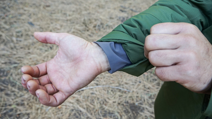 A man demonstrates the sleeve cuffs of the REI Stormhenge Down Hybrid Parka.