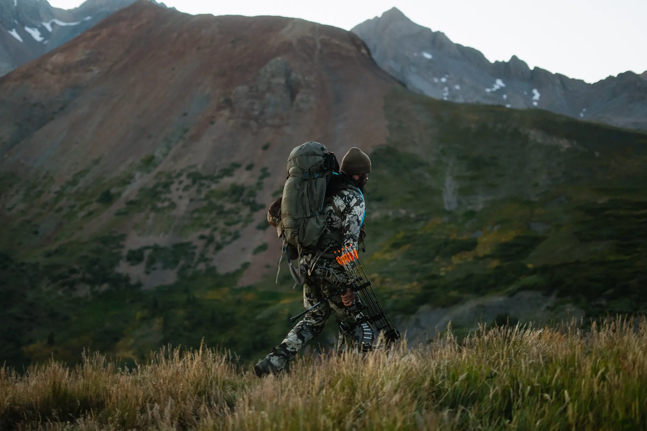 Author carrying hunting gear over mountainous landscape