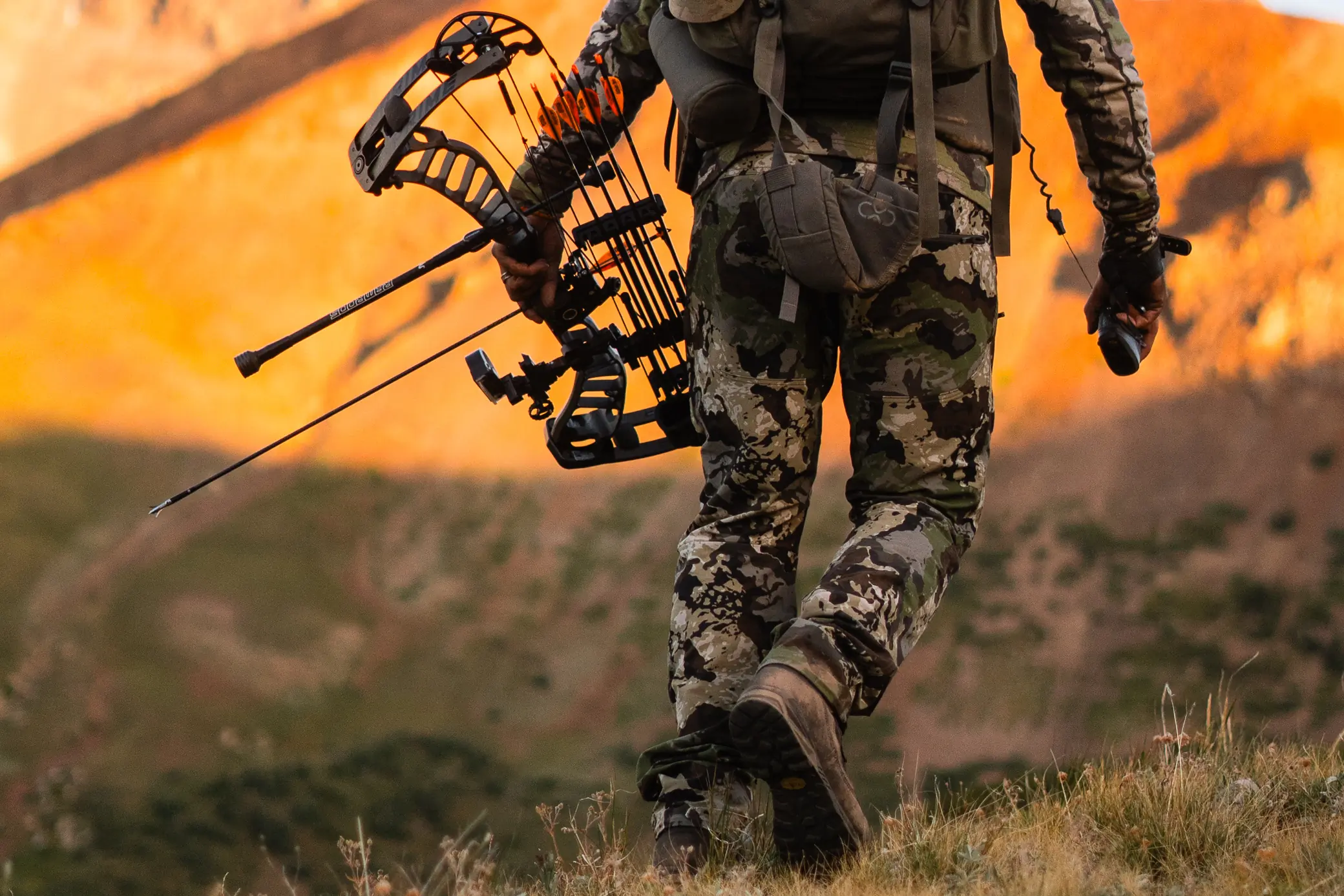 hunter walking holding a bow wearing the pnuma's Pursuit Pant