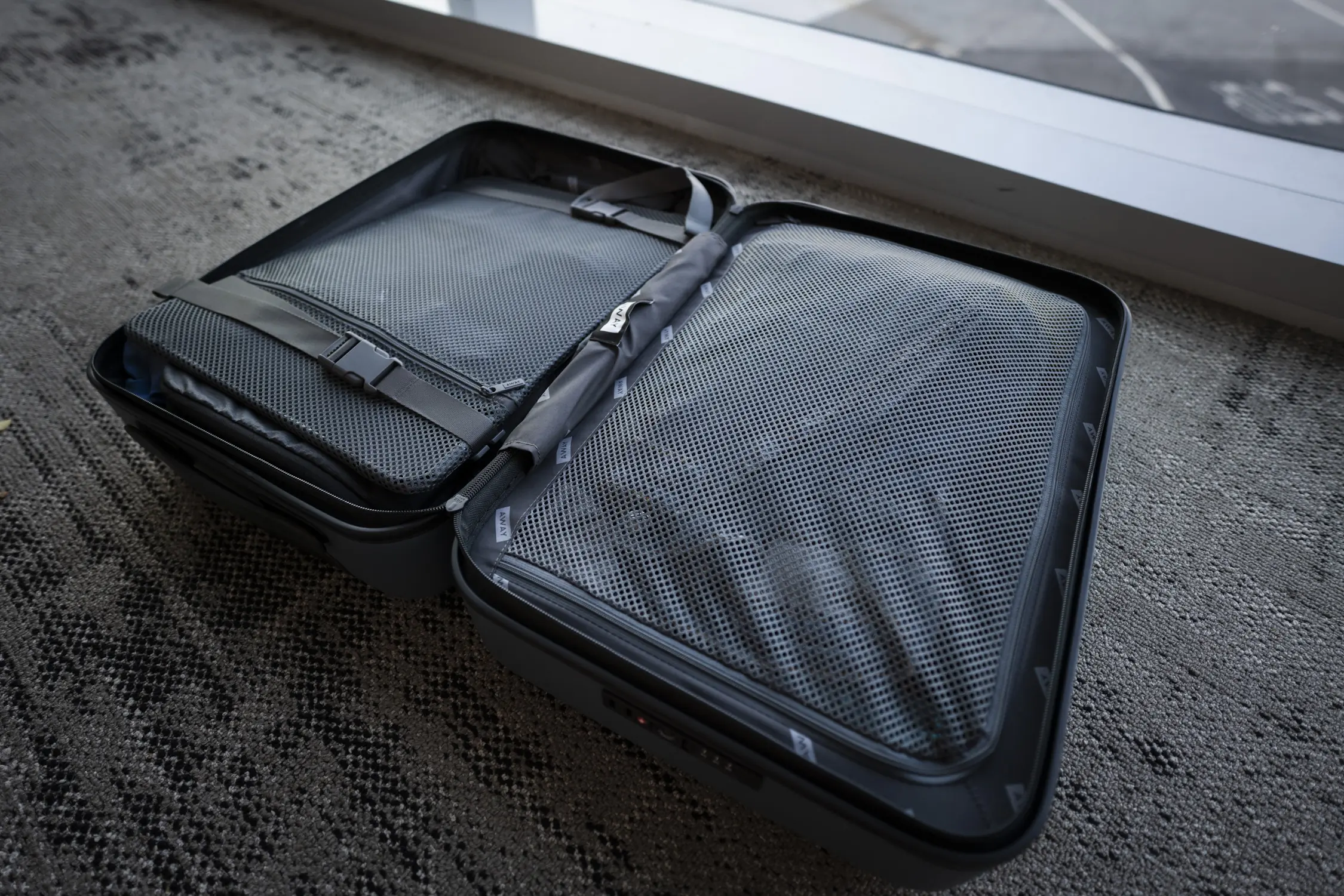 A piece of carry-on luggage opened up on the floor.