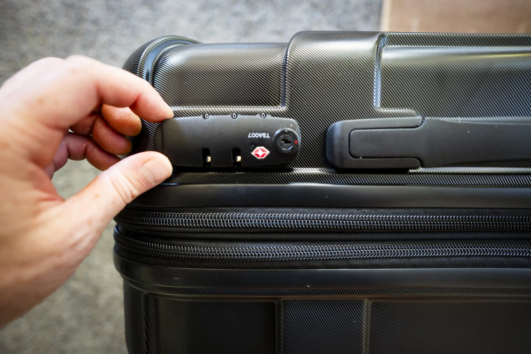 A close up shot of a carry-on luggage and its locking mechanism