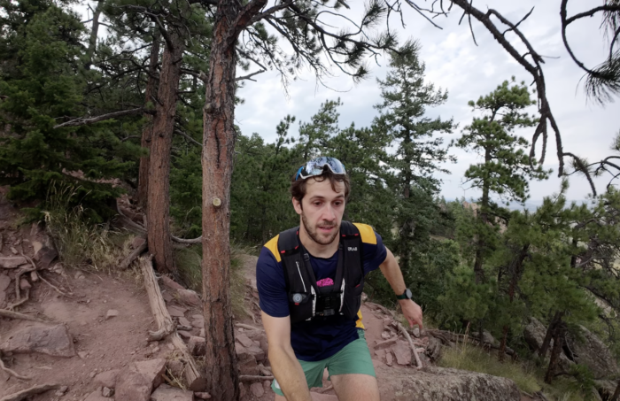 a white male in a running vest testing the DJI Osmo action camera on a backward-facing POV while trail running