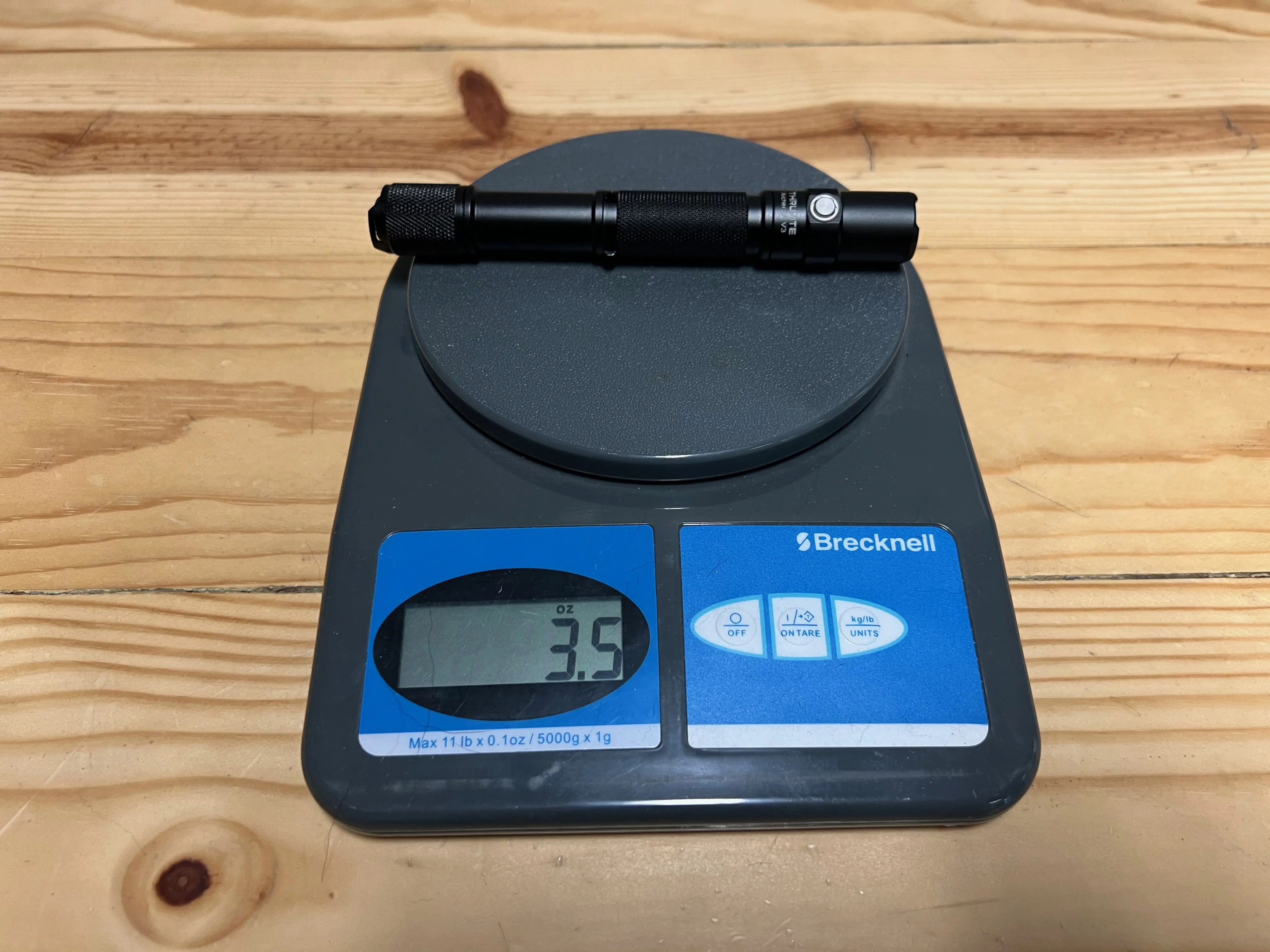 Flashlight weight testing the Trunite Archer on a scale