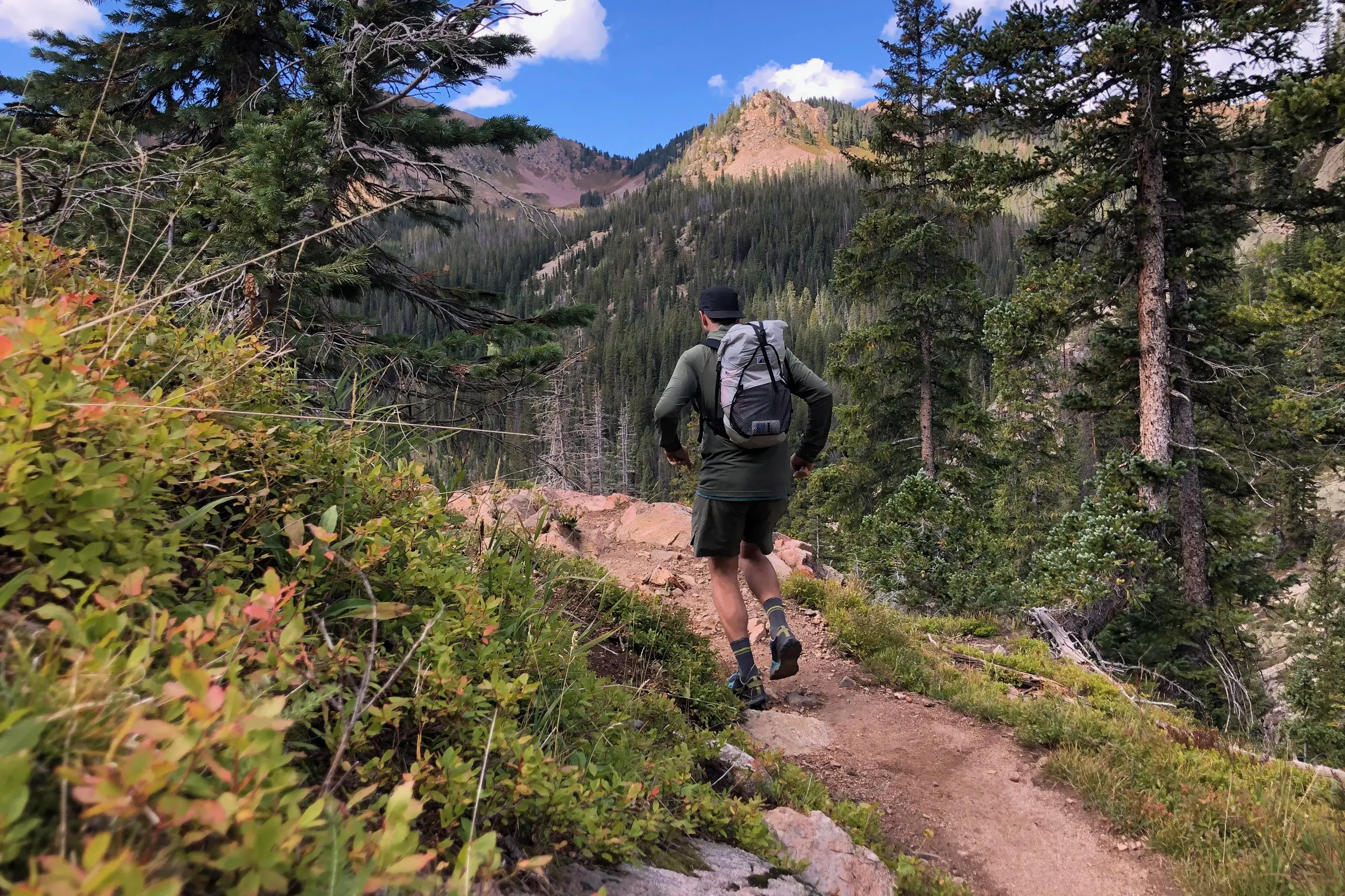 man going a hiking trail wearing a lightweight backpack