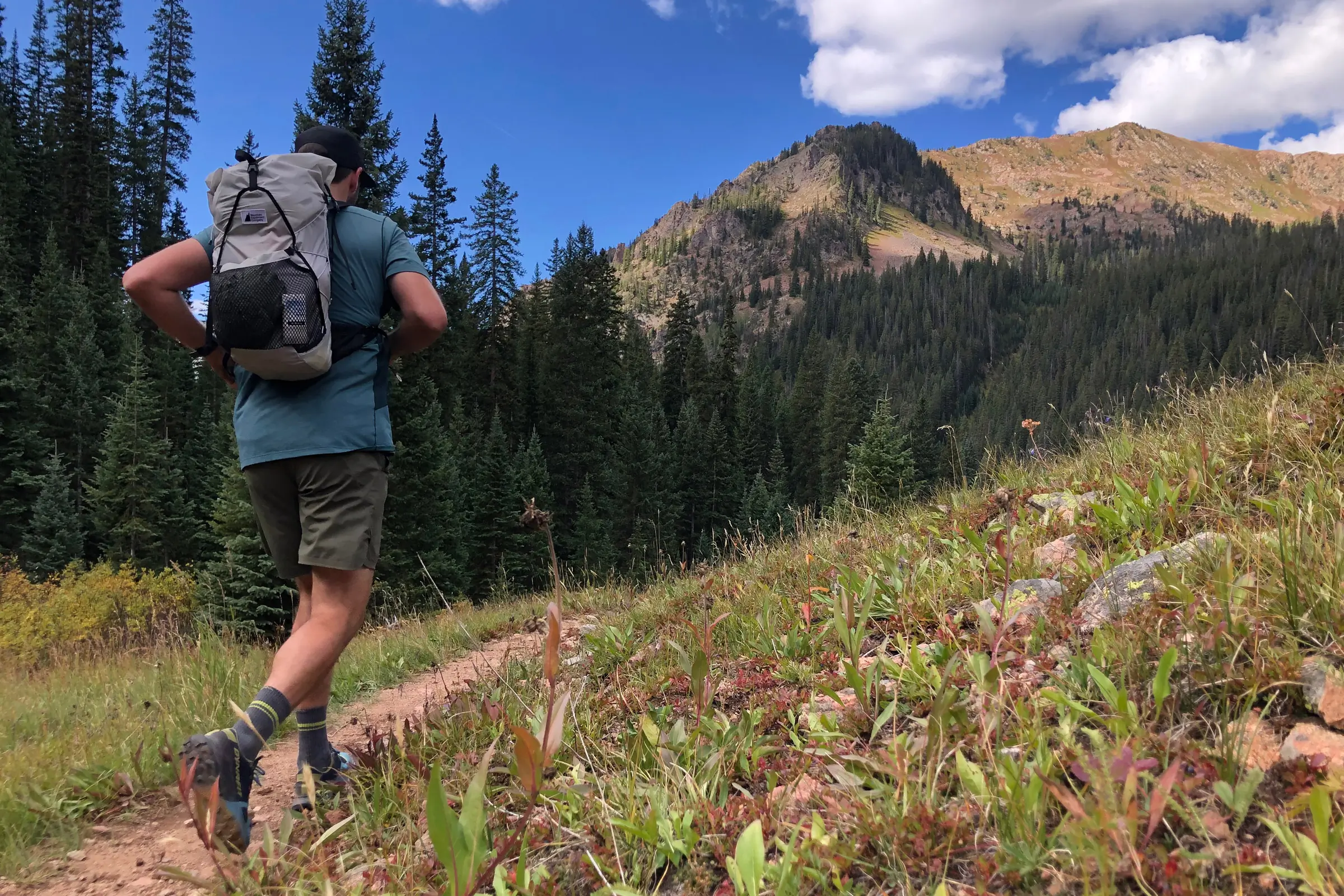 person going on a hiking trail using a lightweight backpack