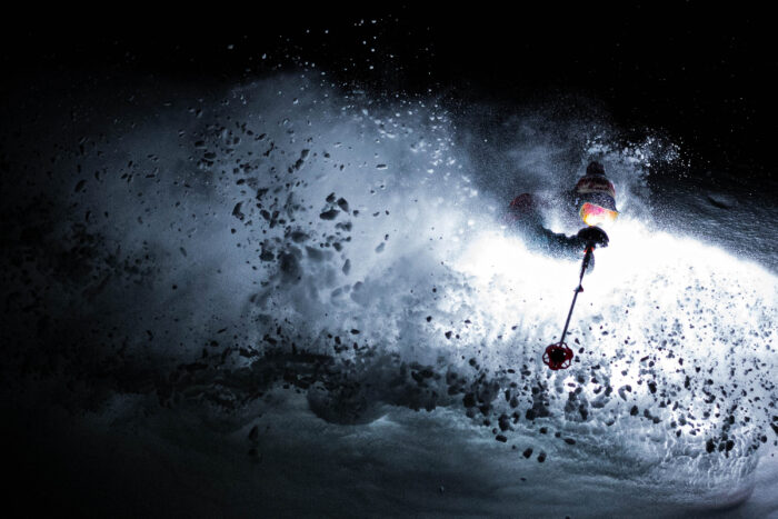 a skier comes to a stop in the dark