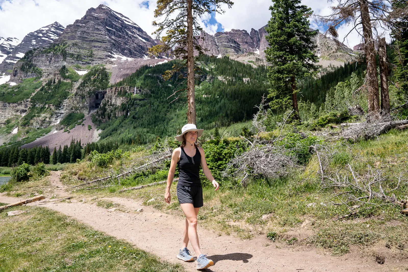 Walking down a mountain trail while wearing one of the best sun hats of 2023