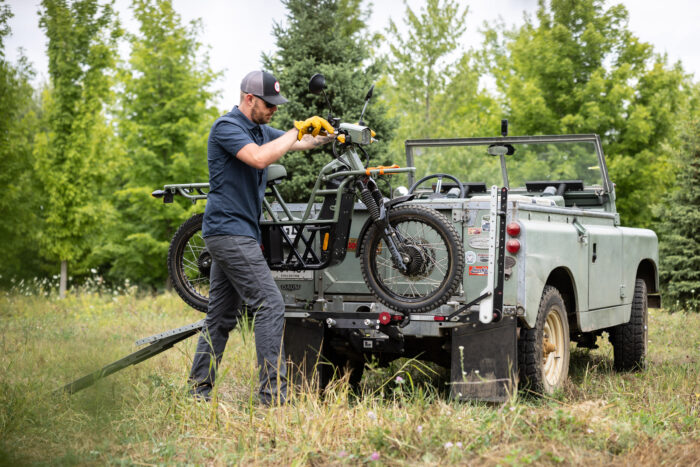 person loading a motorbike to the 1Up 2" Xtreme Duty Single Hitch Bicycle Rack