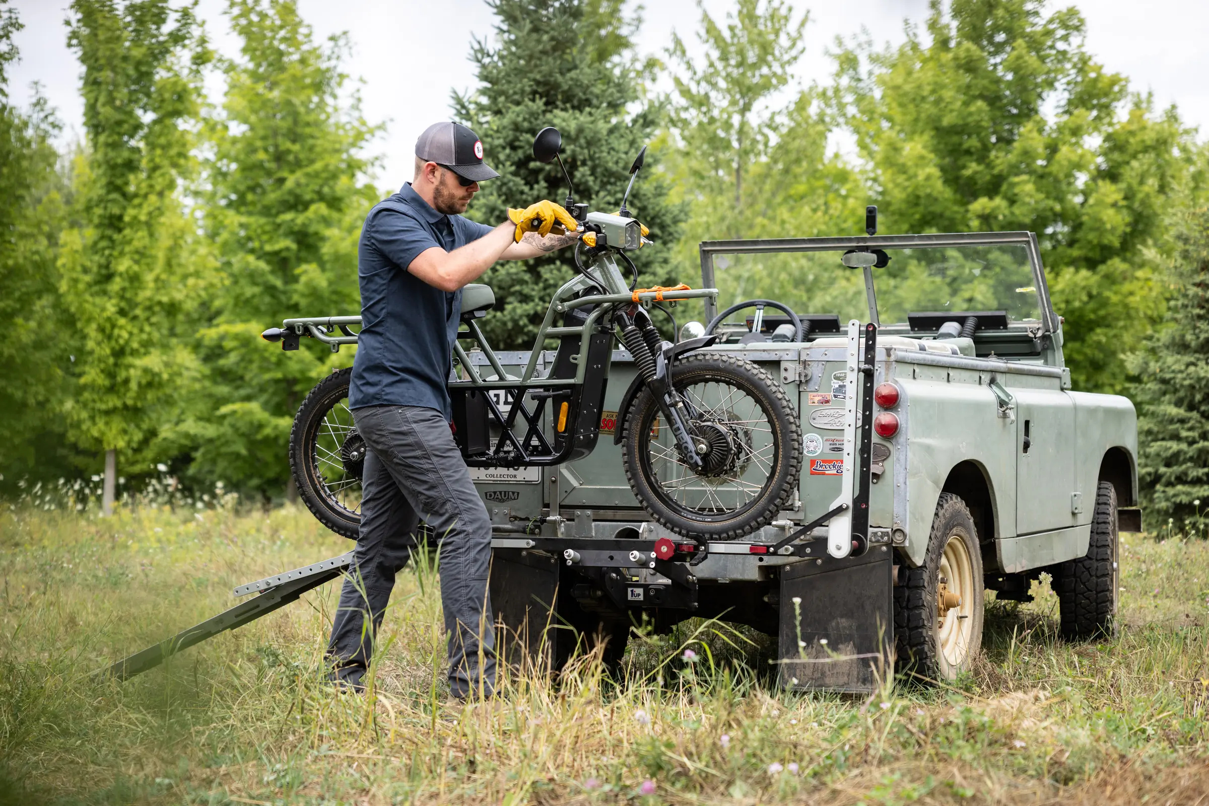 person loading a motorbike to the 1Up 2" Xtreme Duty Single Hitch Bicycle Rack