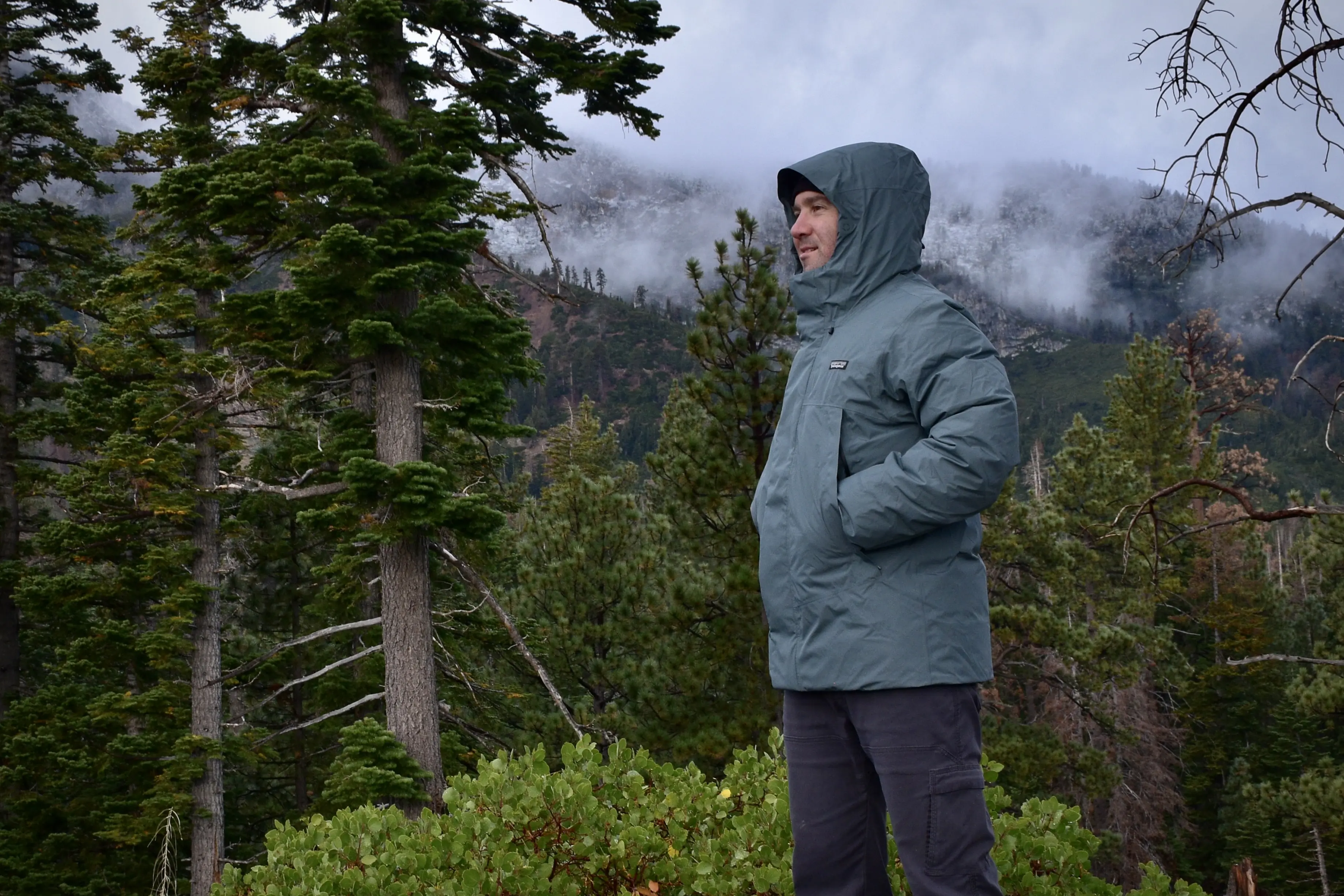 Man wearing the Patagonia Stormshadow Parka in front of Mt. Tallac