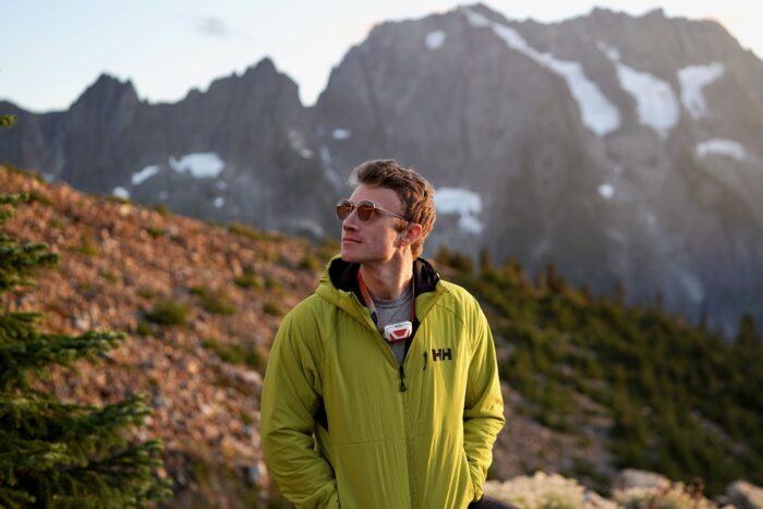 Man wears a synthetic jacket in front of a mountain