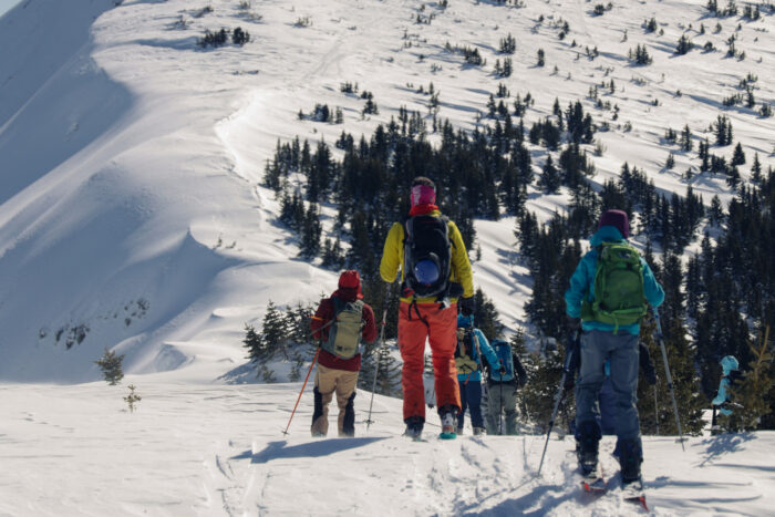 Group of skiers getting ready to go through a snowy mountain trail