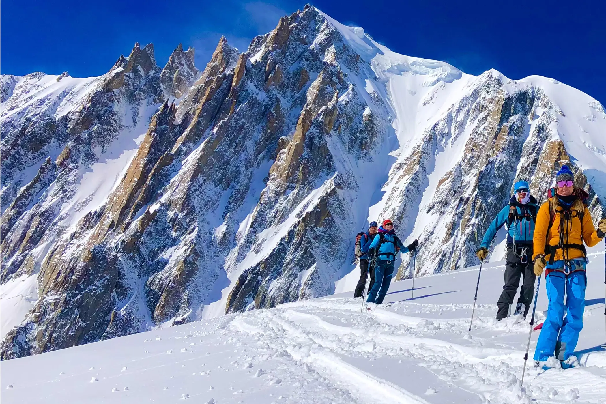 Group of skiers going through a snowy mountain trail