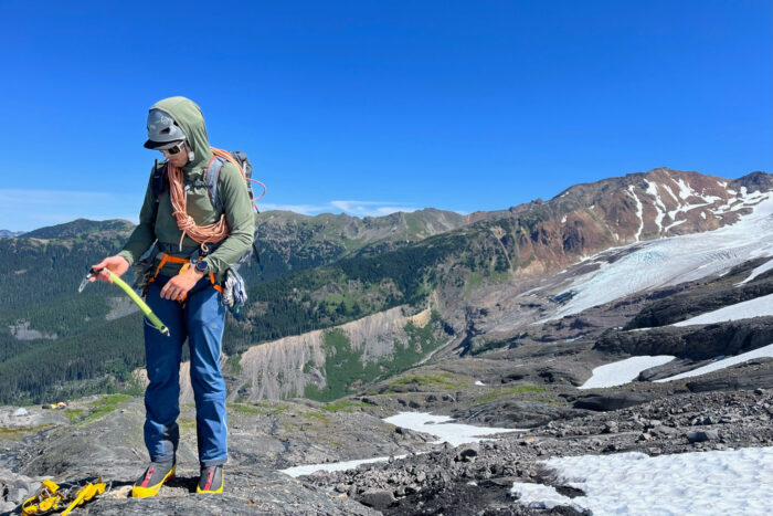 Person with ice mountaineering gear holding an ice ax