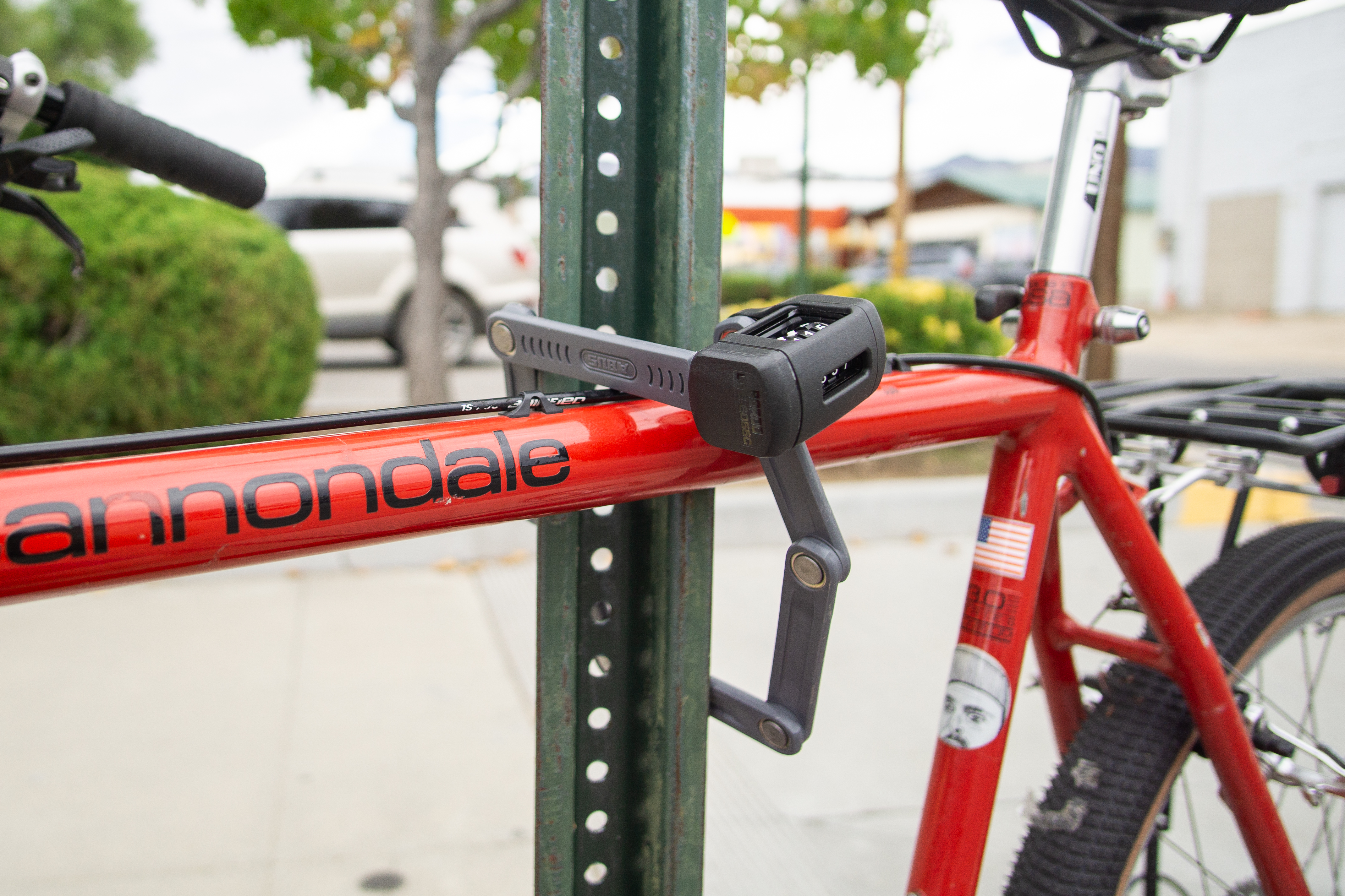 The Abus Bordo 5700 bike lock attached to a bike and metal pole.
