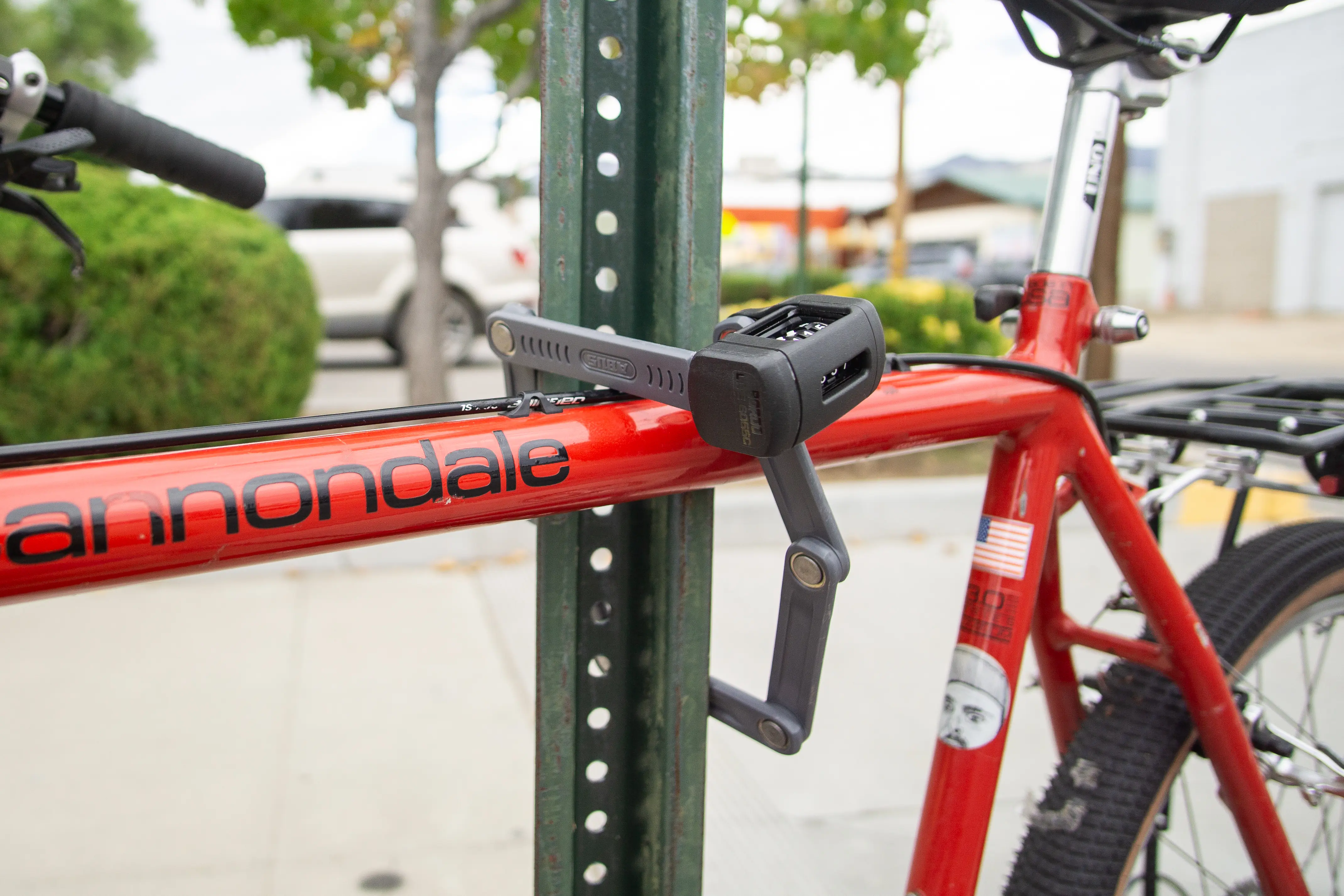 The Abus Bordo 5700 bike lock attached to a bike and metal pole.