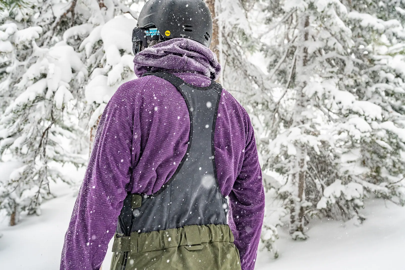 skier standing with his back toward camera with mesh ski bibs on 