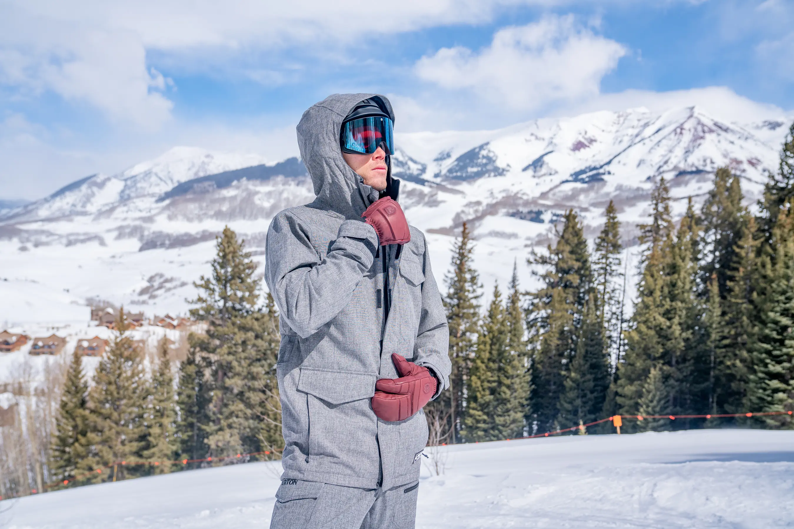 snowboarder pulling up center zipper on snowboard jacket 