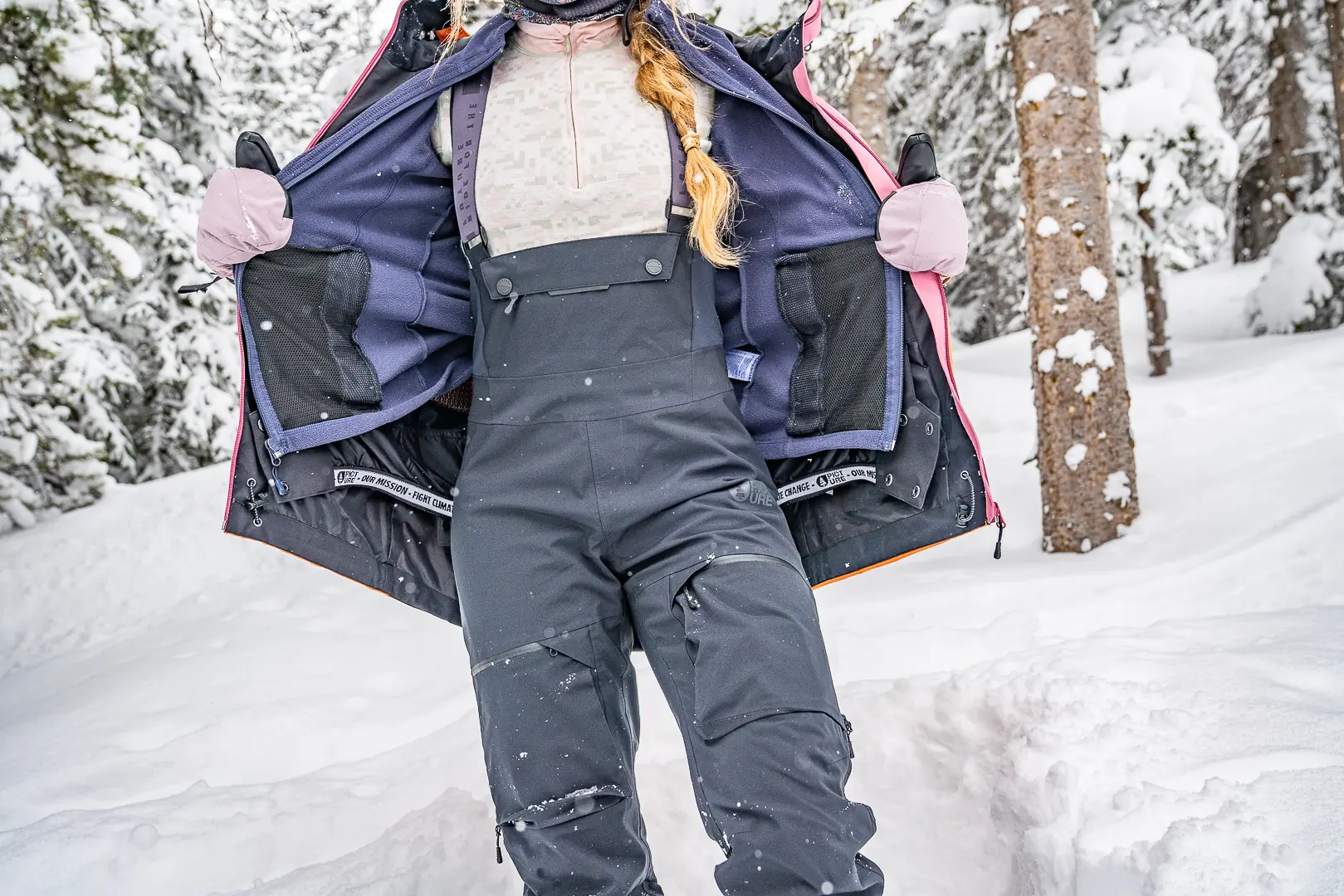 woman holding open jacket while wearing mittens 