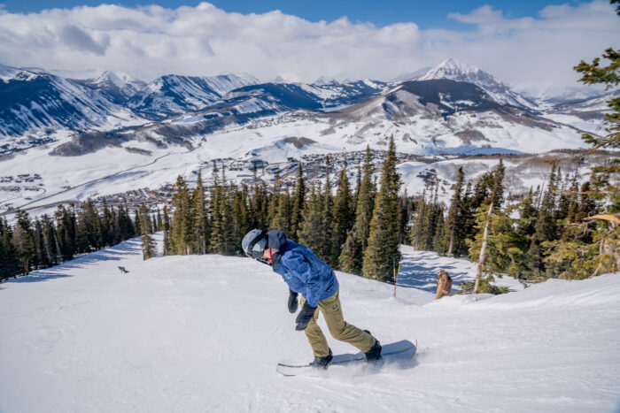 snowboarder drops into a groomer run 