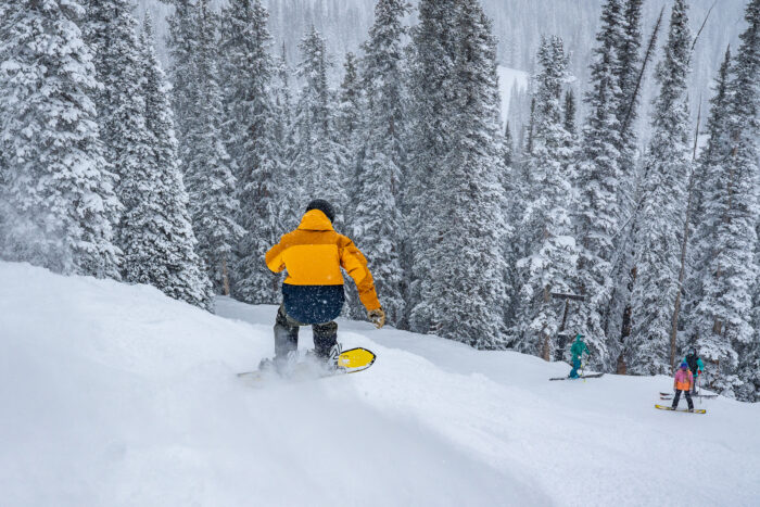 snowboarder getting air off a powder mogul 