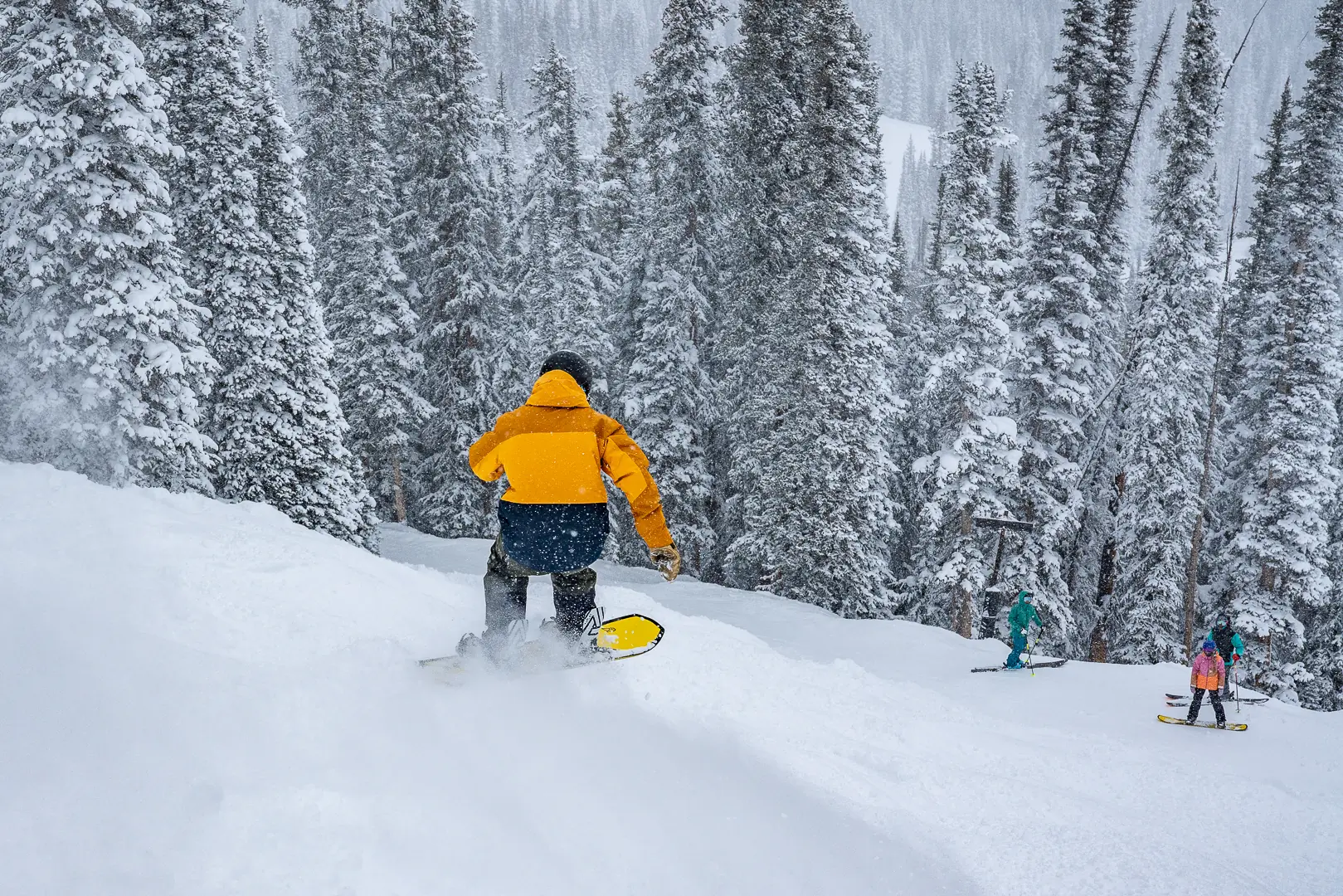 snowboarder getting air off a powder mogul 