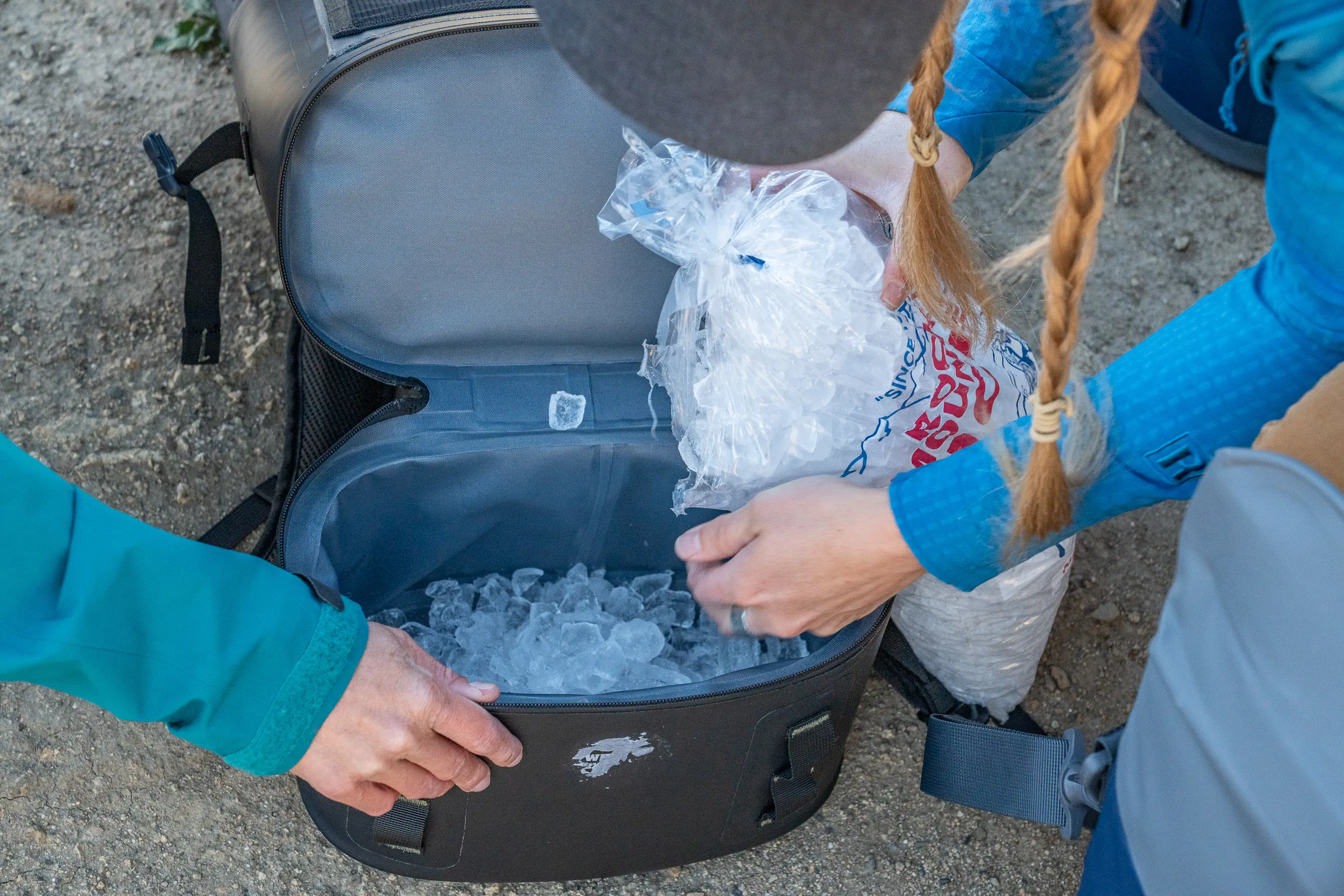 woman putting ice into cooler pack