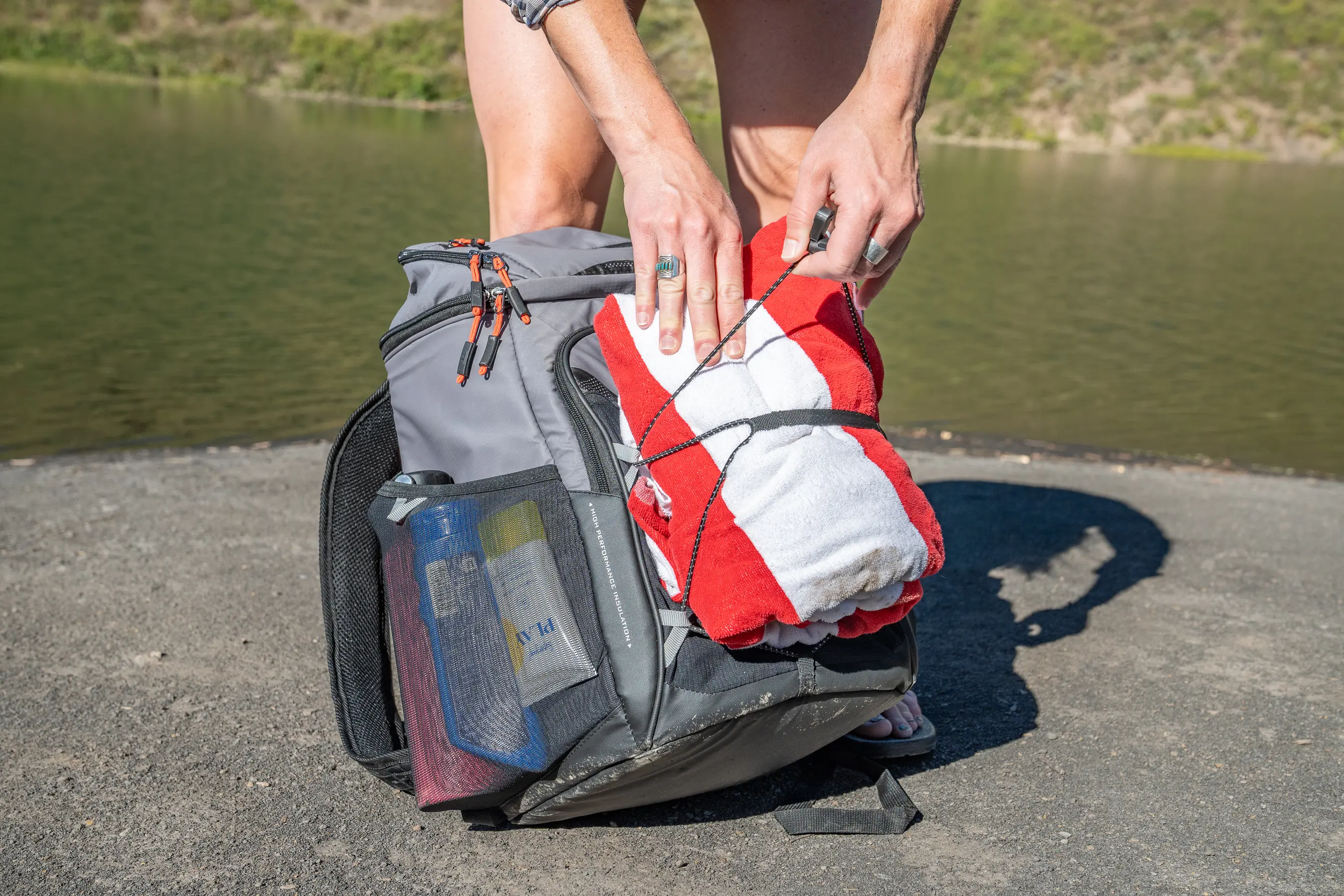 person putting beach towel on pack