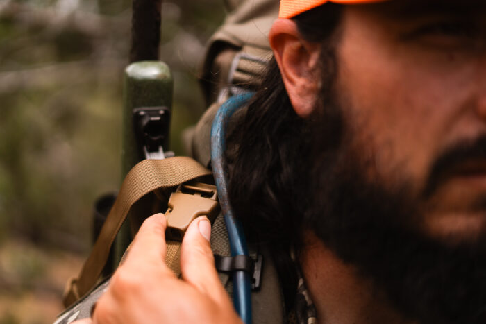 hunter detaching the rifle from the sling using the upper clip feature next to his right shoulder
