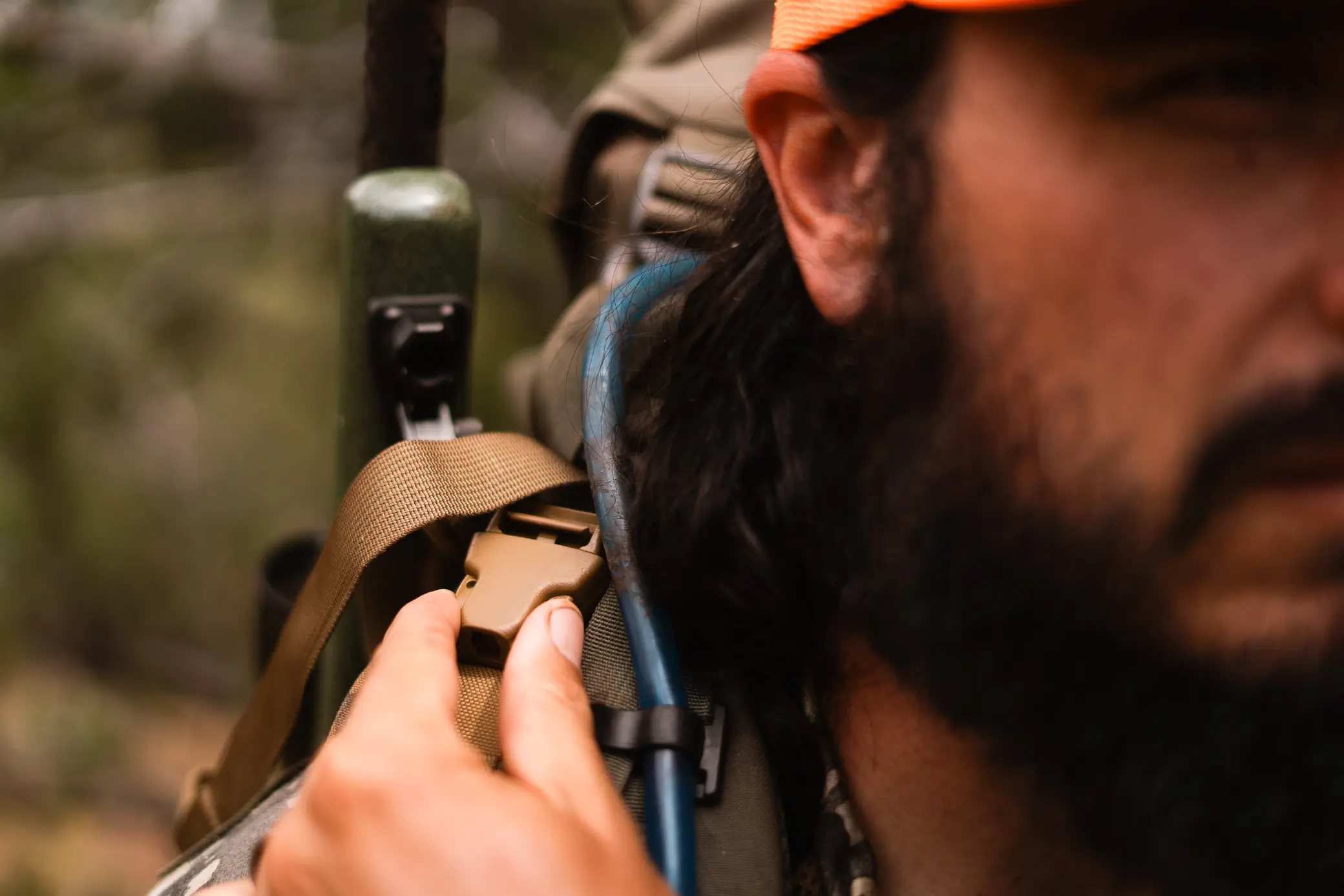 hunter detaching the rifle from the sling using the upper clip feature next to his right shoulder