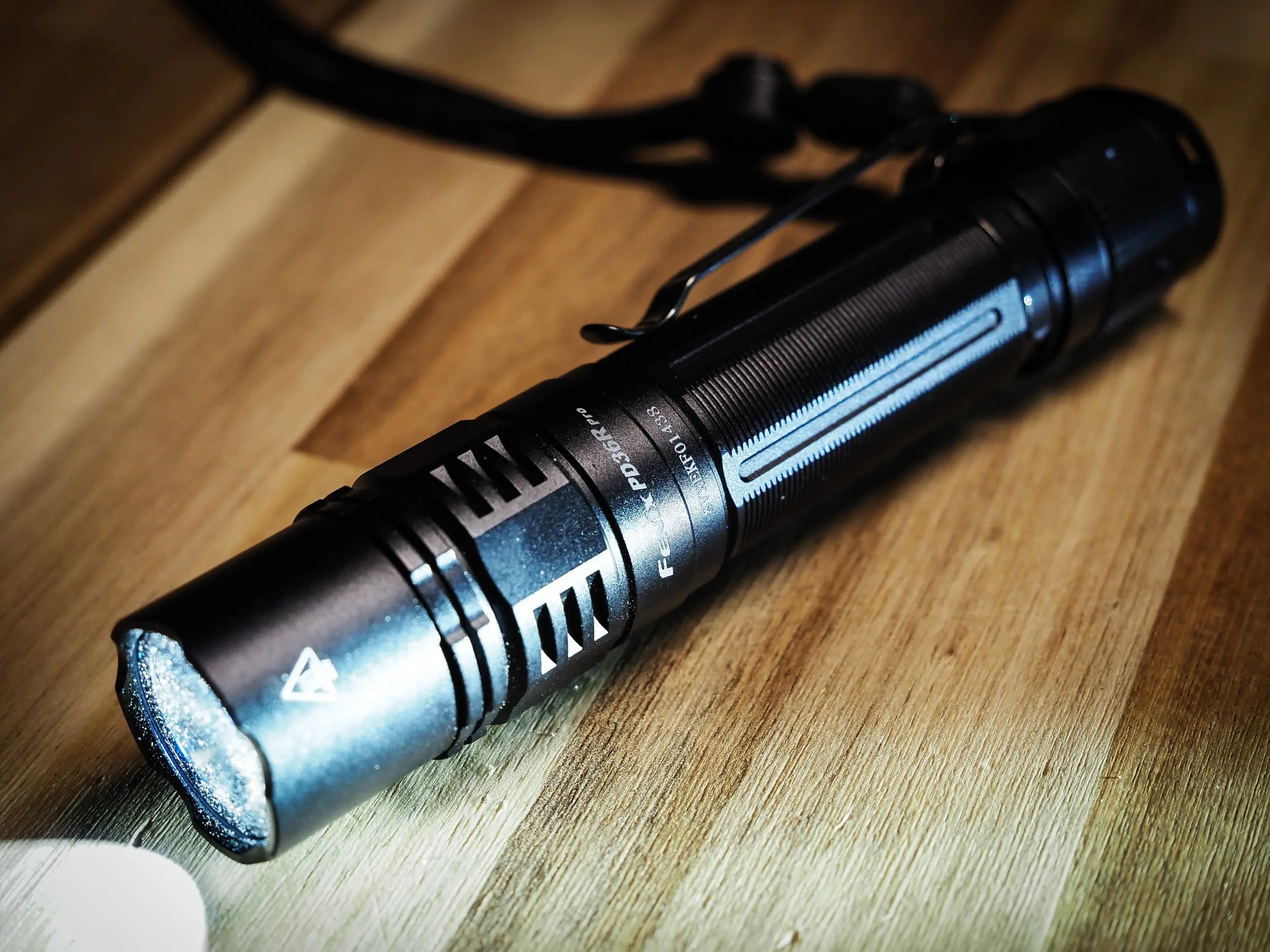 a fenix PD36R pro flashlight sits on a table