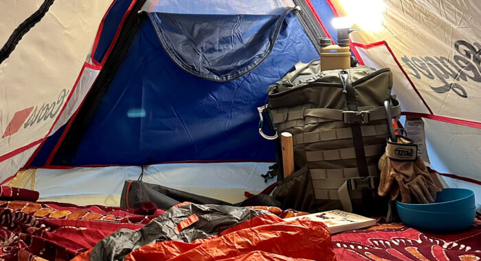 A tent with testing gear and a portable charger and lamp.