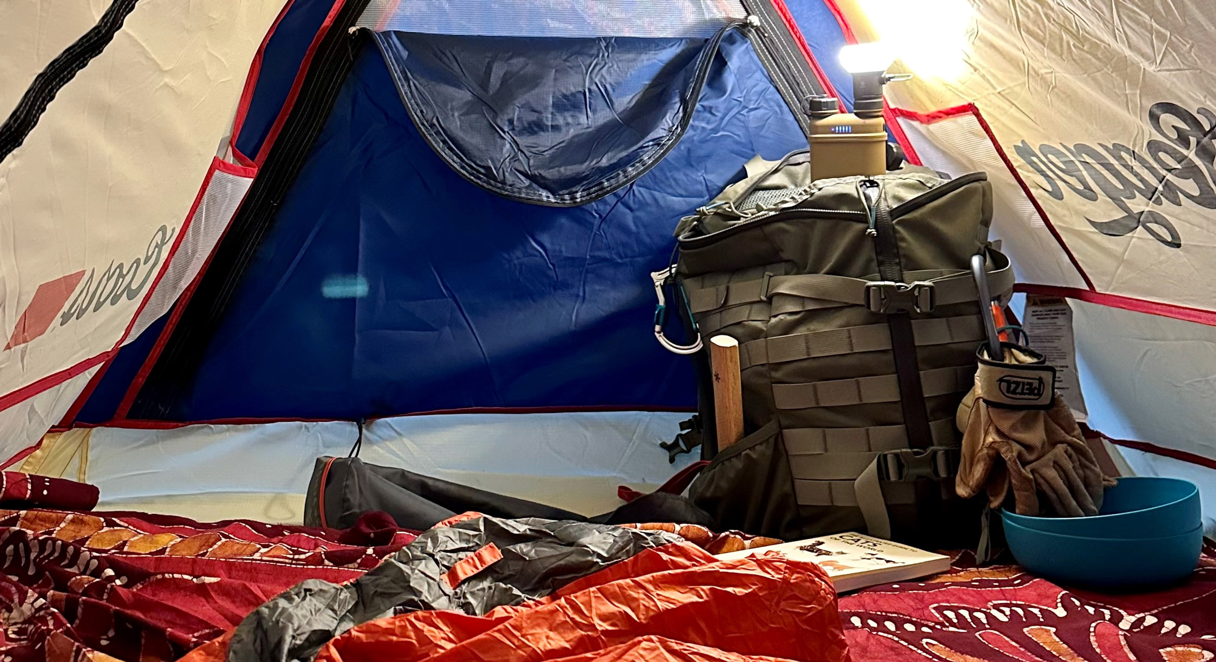 A tent with testing gear and a portable charger and lamp.