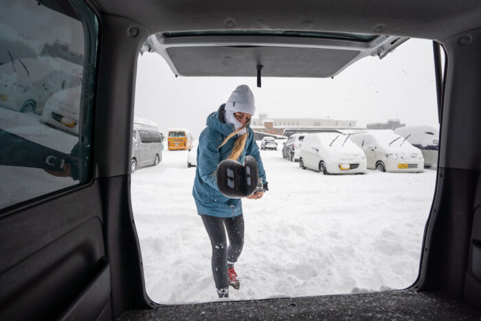 Person loading skies into a car, which makes moving around Niseko much easier.