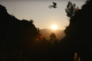 a mountain biker catches major air above a sunset