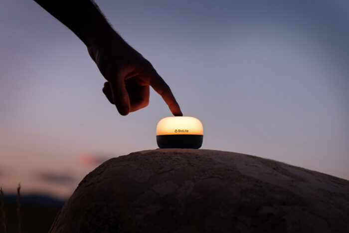 a hand touches a biolite mini lamp