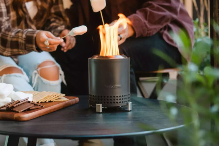 dryrobe Two people roast marshmallows over a solo stove mesa tabletop firepit
