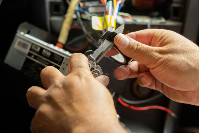 a man uses a leatherman knife to cut electrical tape