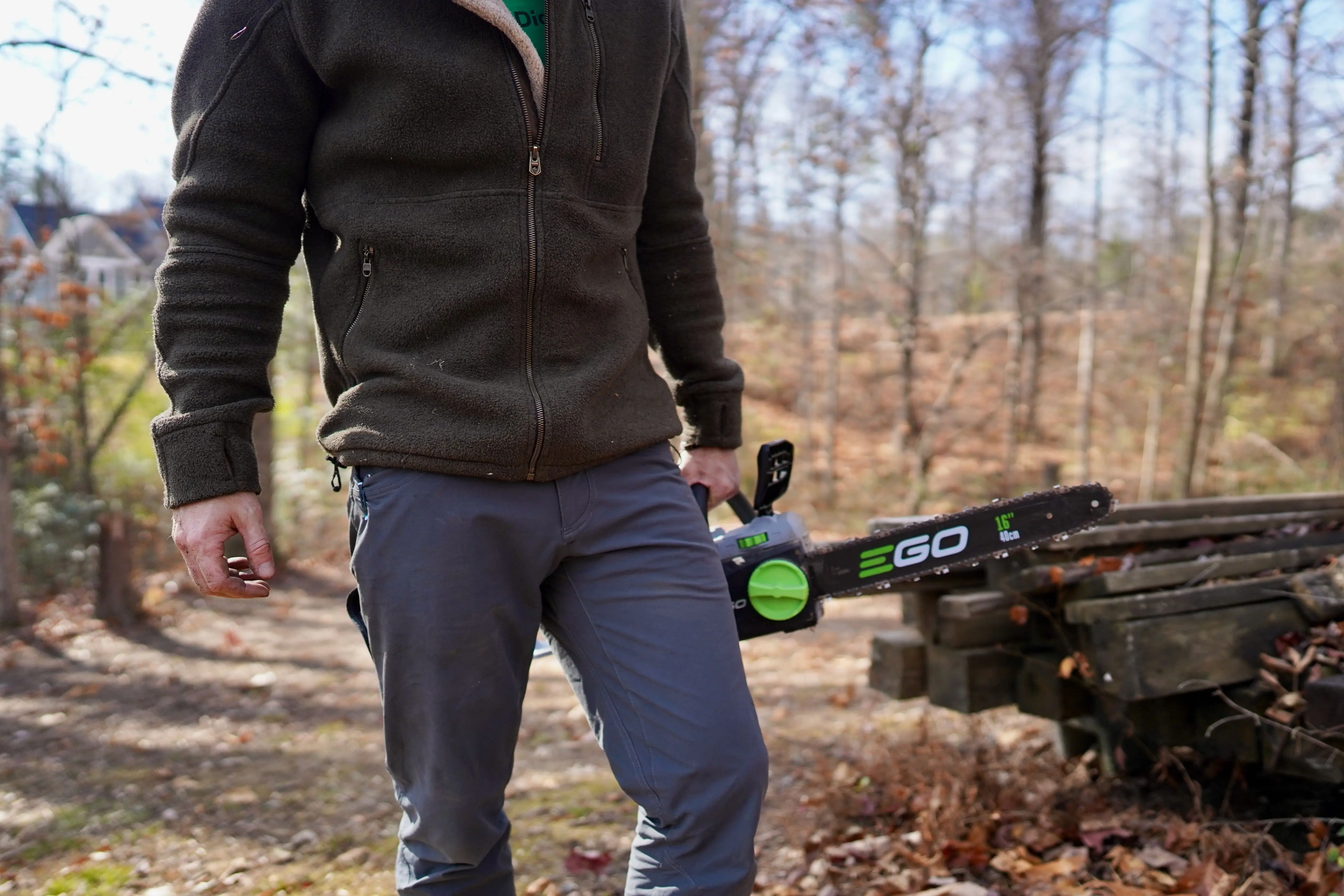 Many in work pants carrying chainsaw