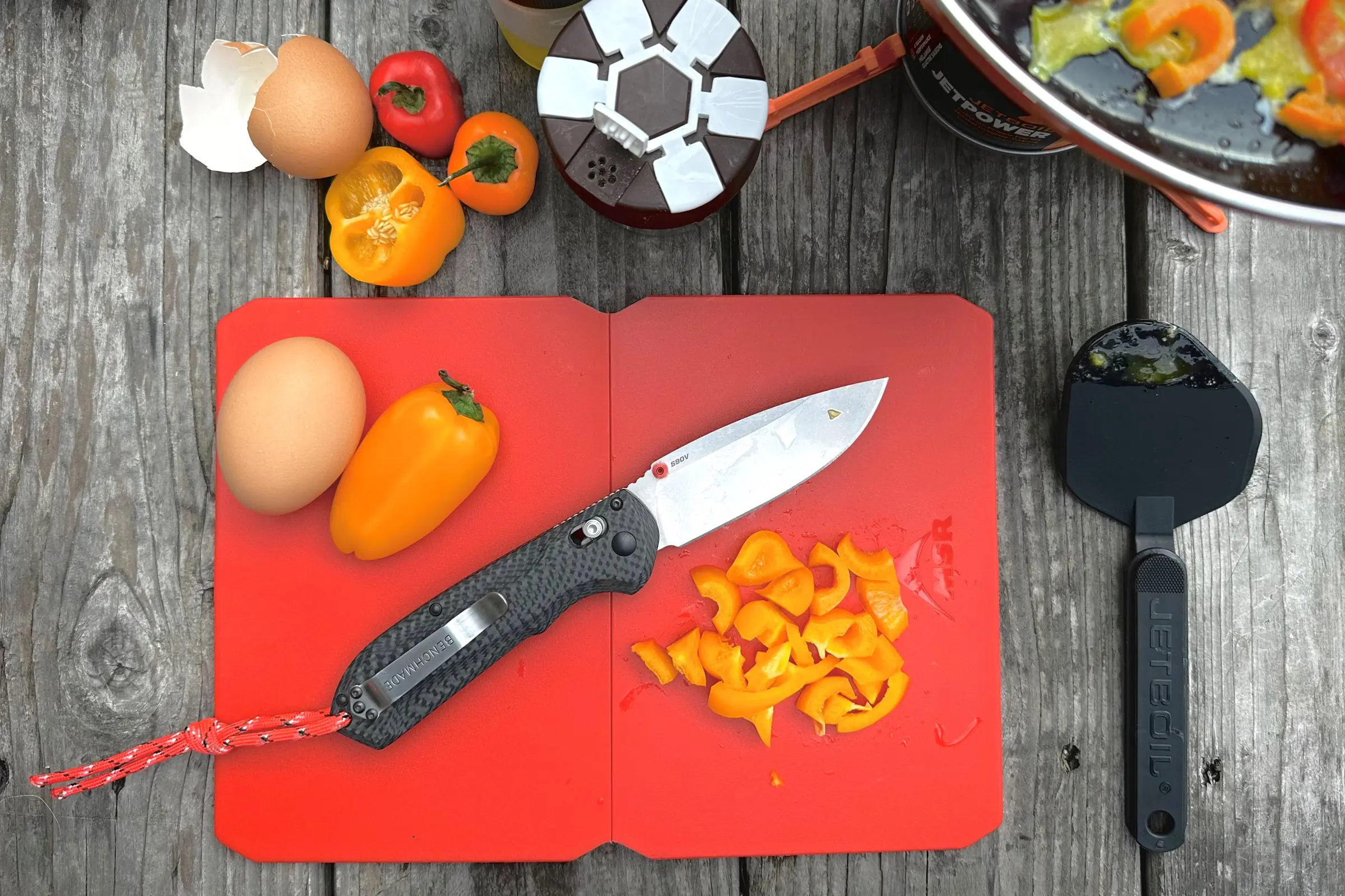 Benchmade freek knife on a cutting board with cutted vegetables around