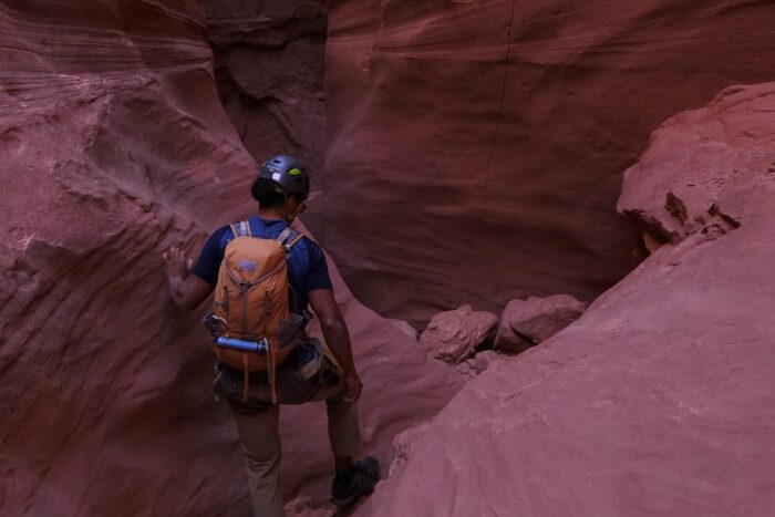 hiker waling through a mountain wearing climbing gear