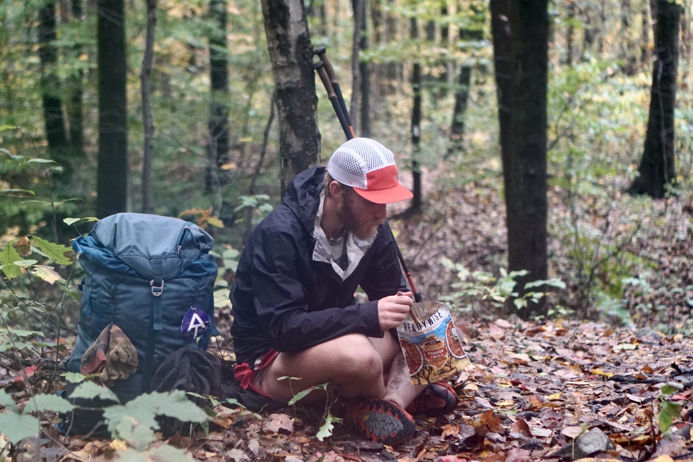 the author sits in the leaves of the appalachian trail eating a readywise meal