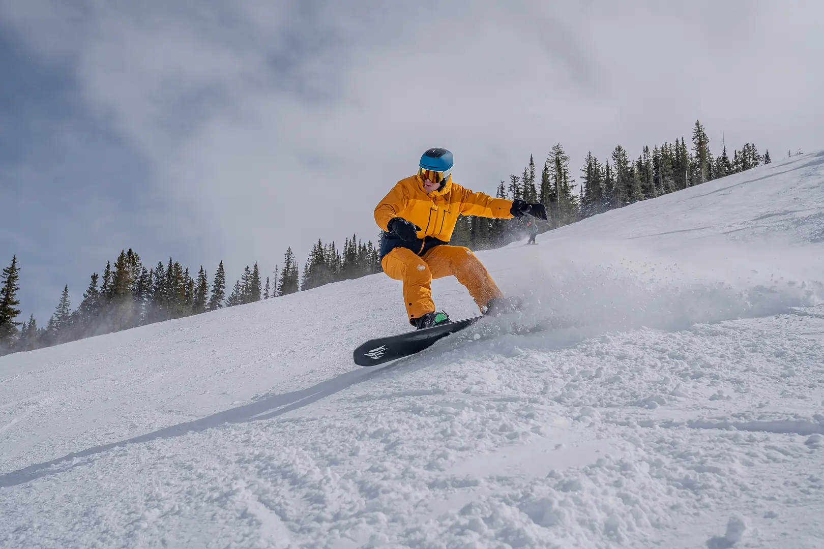 snowboarder carving down steep slope