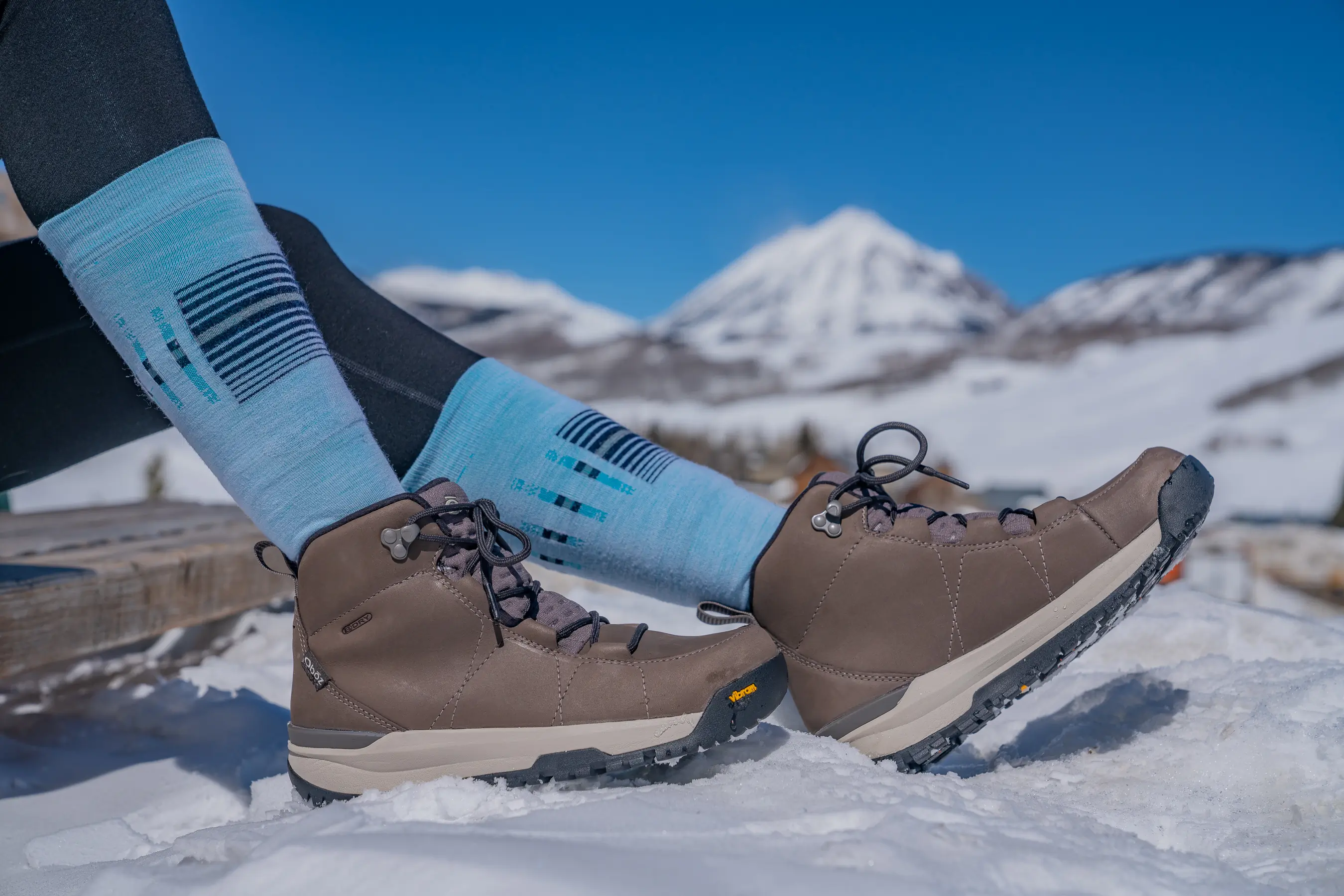 testing women's winter boots while sitting on a wooden bench on a walk break 